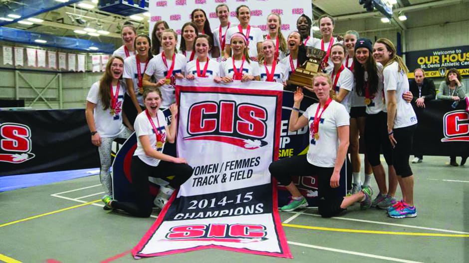 Women’s track and field team poses with CIS championship banner. MARTYN BAZYL/VARSITY BLUES